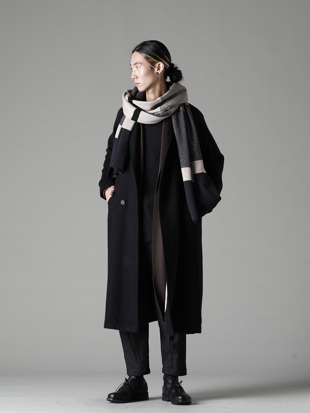 DEVOA(デヴォア) 22-23AW(秋冬) コートのインナーにロングカーディガンをレイヤードし、ボトムスはシェトランドウールリネンのクロップドパンツと短靴を、首元にメリノウールのジャカードストールをチョイスしたスタイリング 全体のバランスを考慮しつつ、冬の屋外と屋内の両方を想定。 - CTI-SSGショールカラーコートブラッシュカシゴラ KTS-SKM-Chocolate ロング カーディガン メリノ ウール チョコレート CSC-WT3-Black ロング スリーブ コットン ジャージー ブラック PTN-SHC クロップド パンツ シェットランド ウール / リネン KAC-ABA ジャカード ストール メリノ ウール FW-CTN レザー シューズ GUIDI カーフ  1-003