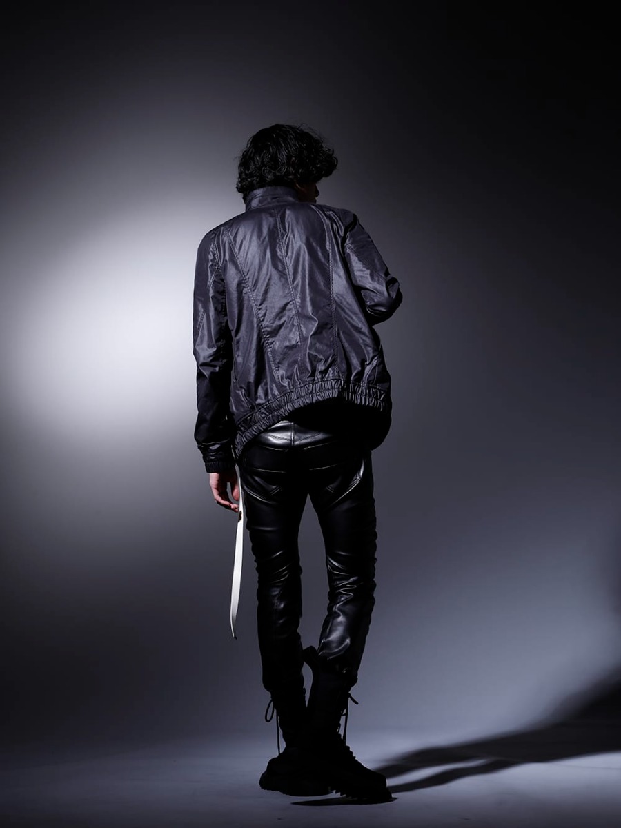 JULIUS 2023SS  - The styling is characterized by luster and military details. - 797BLM7(Cargo Blouson Polyester Cotton Cloth) 817CPM3-Black(Cotton/Modal Jersey Front Print Short Sleeve T-Shirt Black) 807PAM8(Synthetic Leather Pleather Indirect Pants) 807FWM1(Cow Velor Lace Up Combat Boots) 817ACU15-silver(Chain Necklace Silver) 807ACU1-Off-White(Cow Skin / Nylon Tape Belt Off White) - 1-004